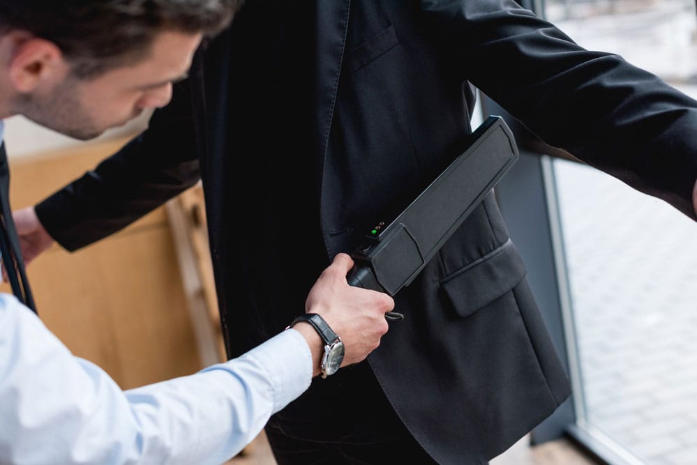 A Guard Using a Metal Detector